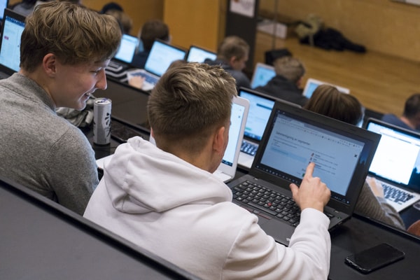 Learners playing a business simulation together in a classroom